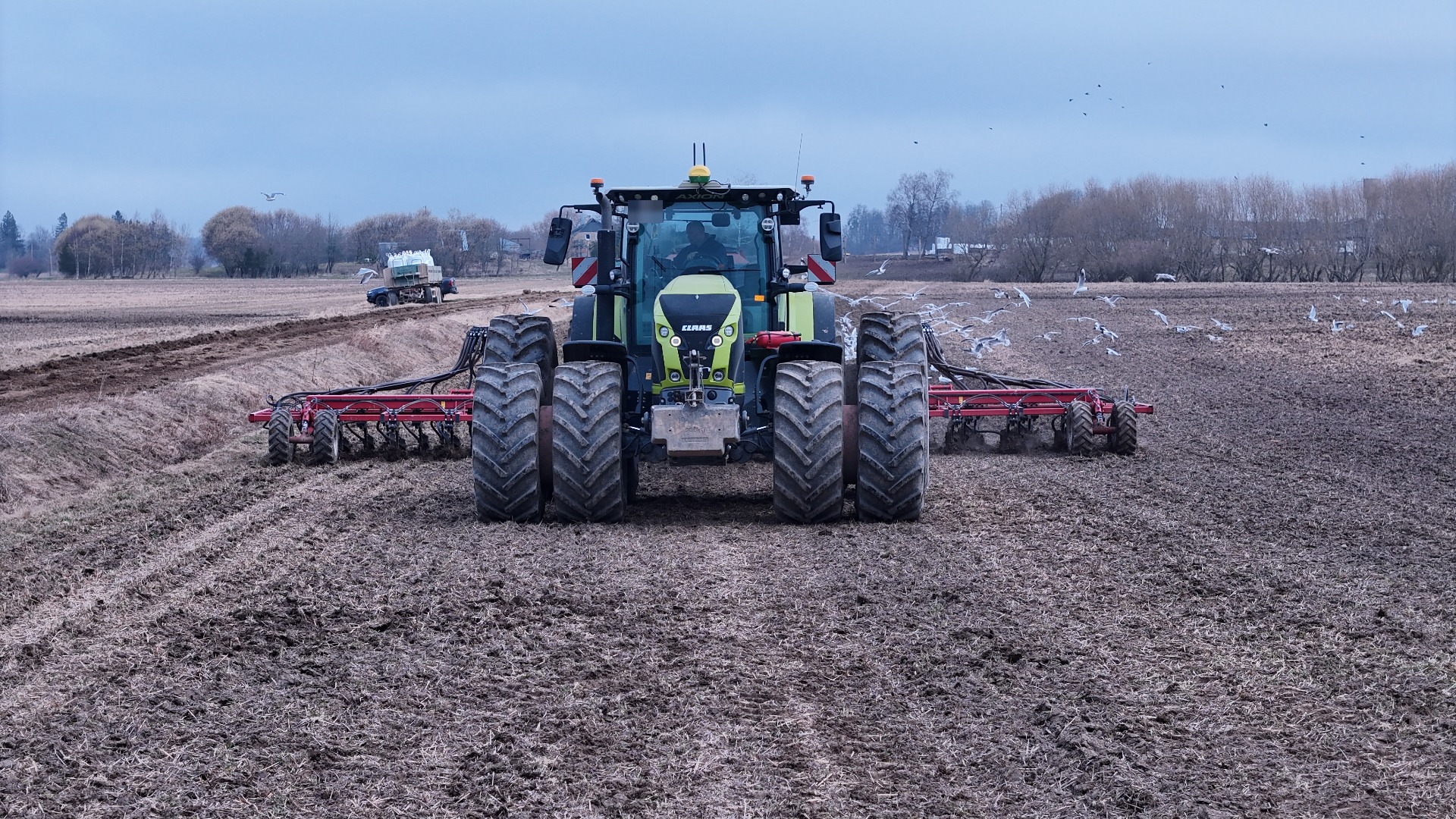 Claas Axion ar dvīņu riepām augsnes apstrādē