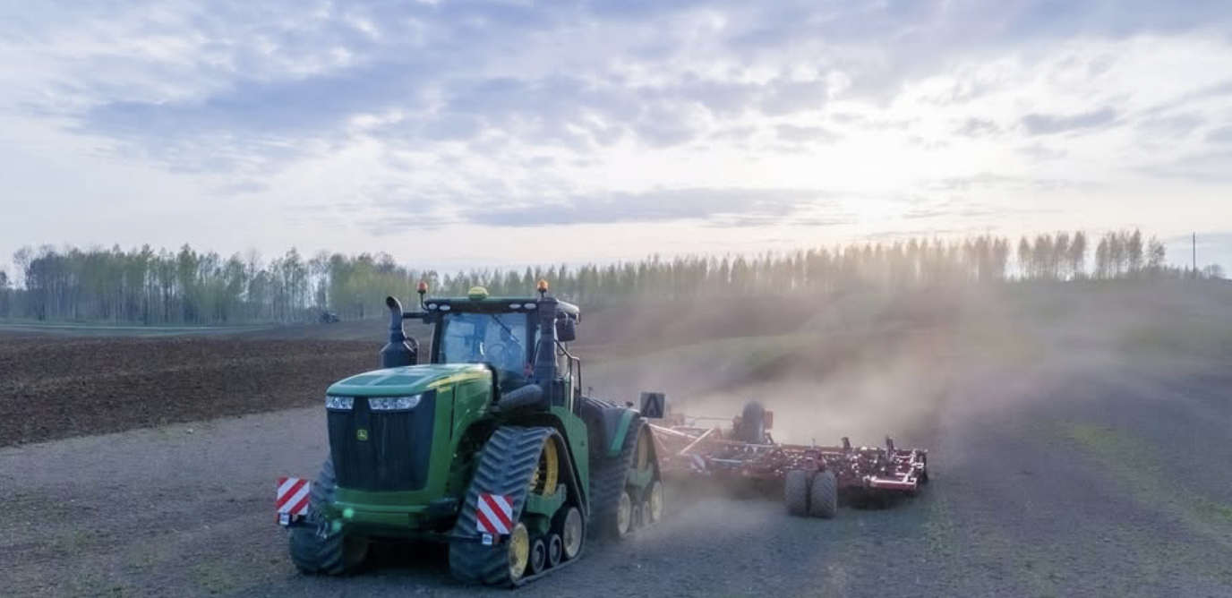 John Deere kāpurķēžu traktors ar kultivatoru krēslā