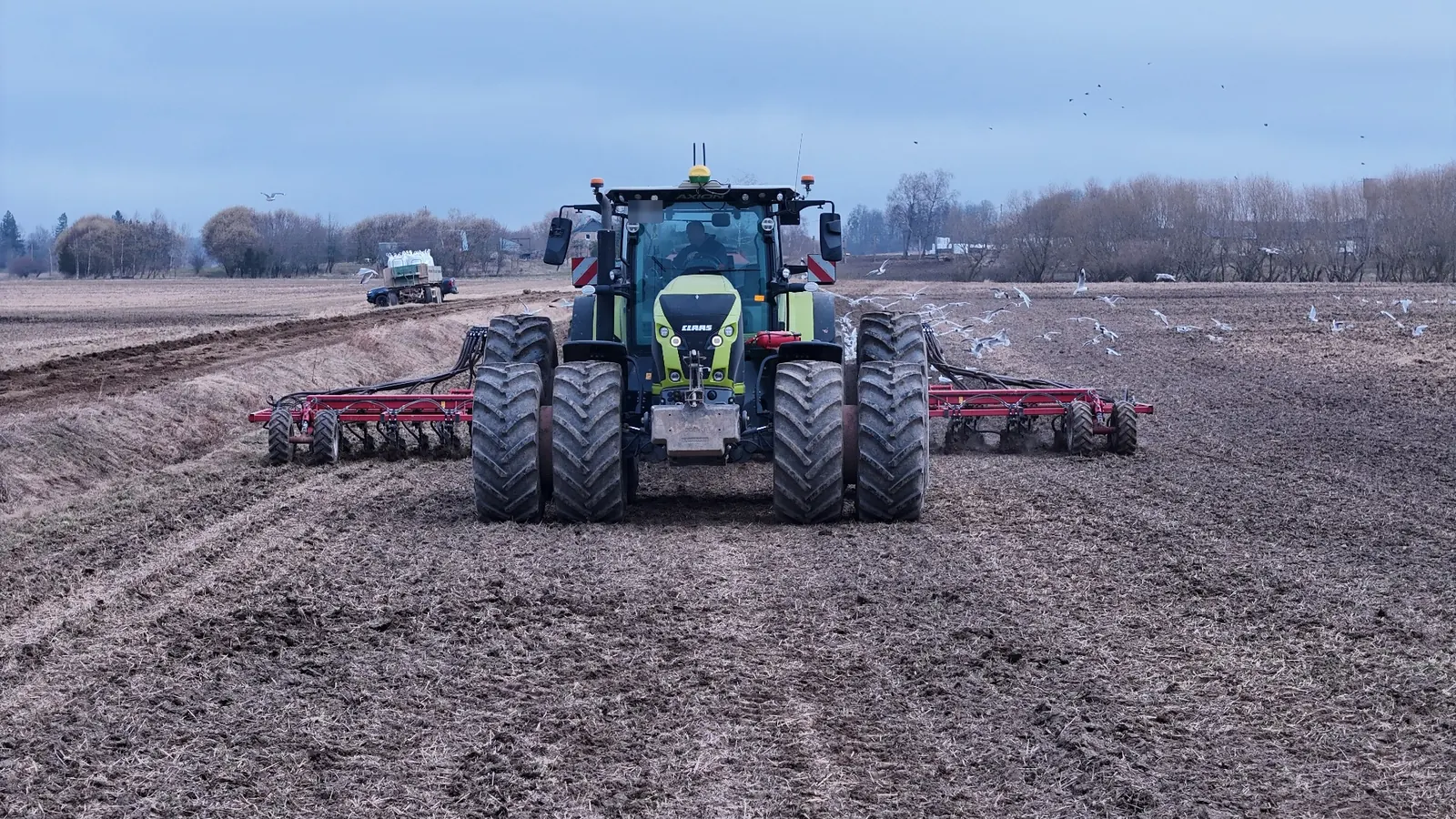 Claas Axion ar dvīņu riepām augsnes apstrādē